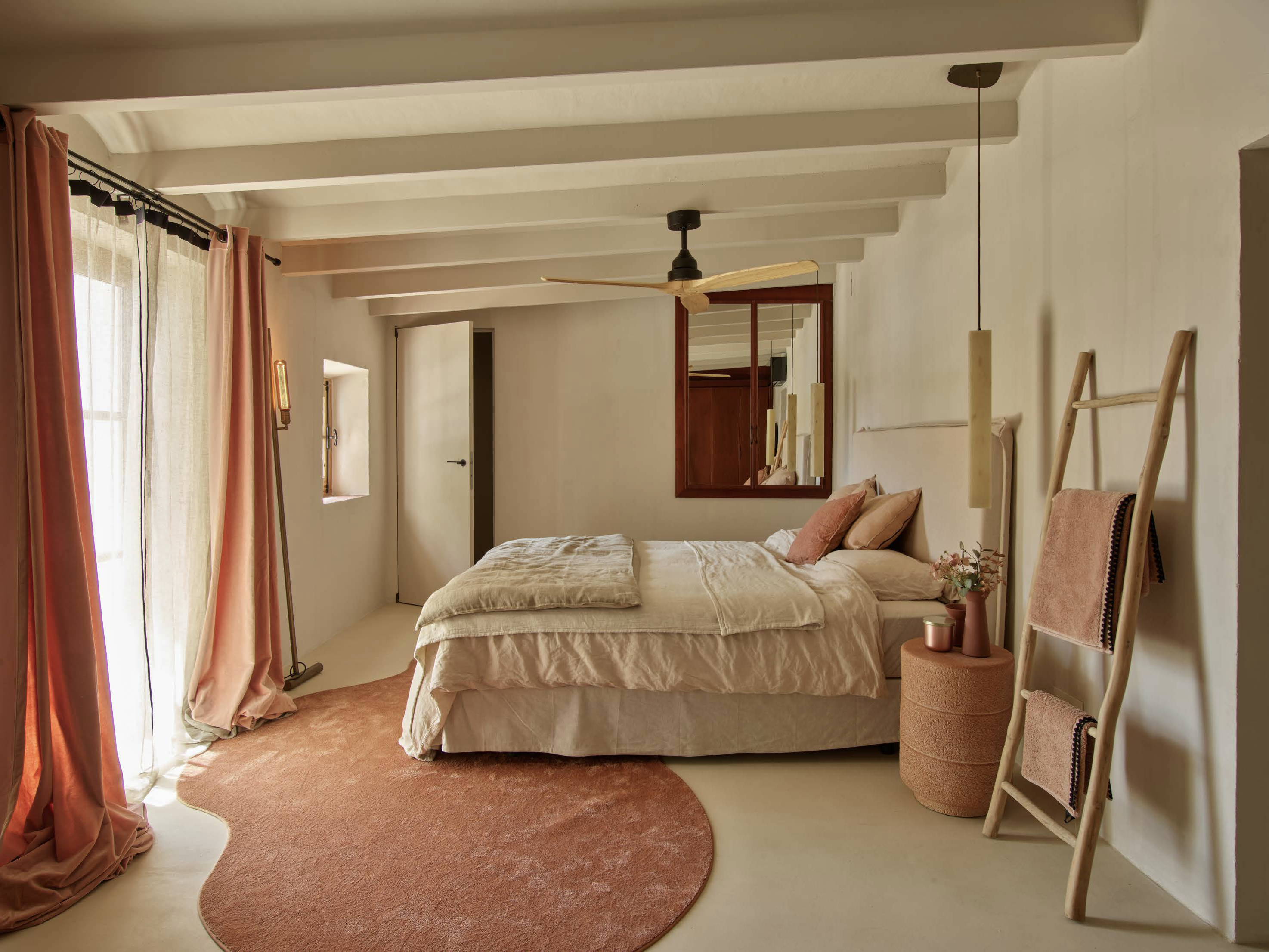 Cozy rustic bedroom with warm pink accents and natural light
